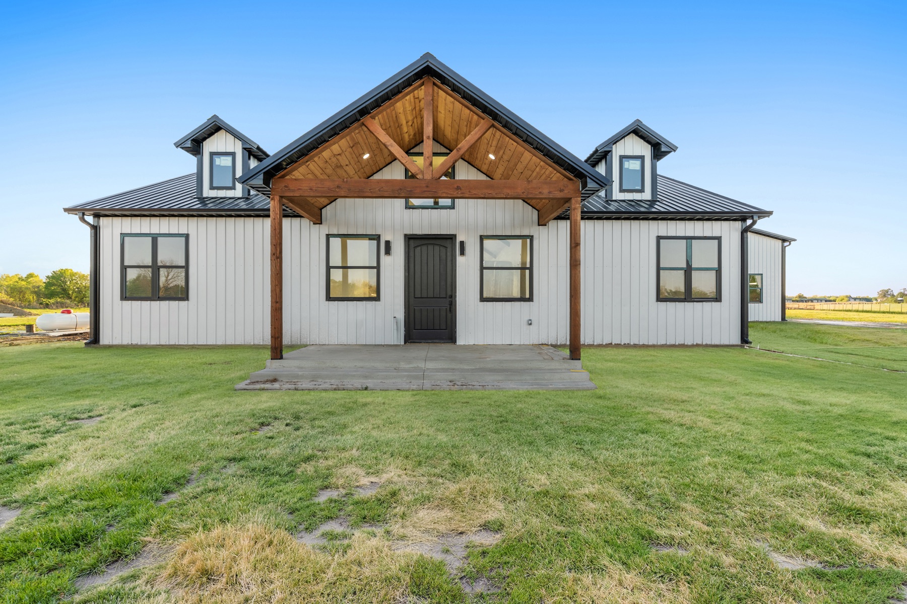 Custom farmhouse front elevation with cedar truss entry